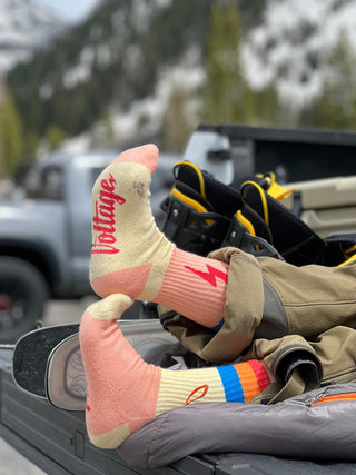 Feet kicked up on the edge of a truck bed wearing magic wool socks