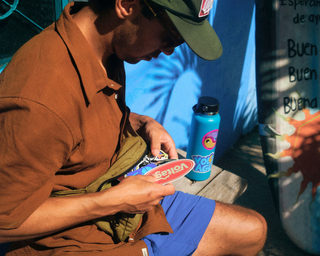 Man going through a stack of voltage stickers on a bench