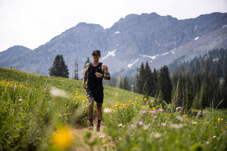 Johnny Collinson trail running through a flowery field wearing blood kom socks