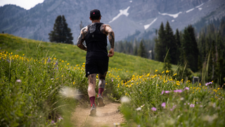 Johnny Collinson trail running through a field of flowers