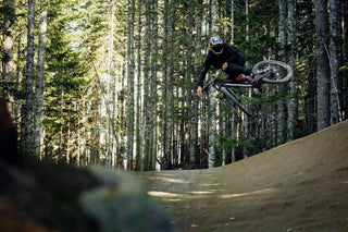 Tom Bunney Jumping a Mountain Bike in the Forest